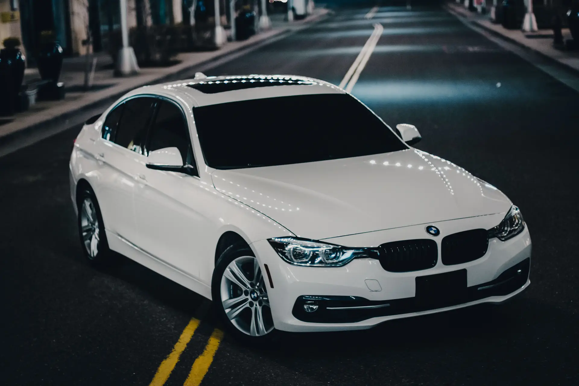 Luxury sedan on city street at night
