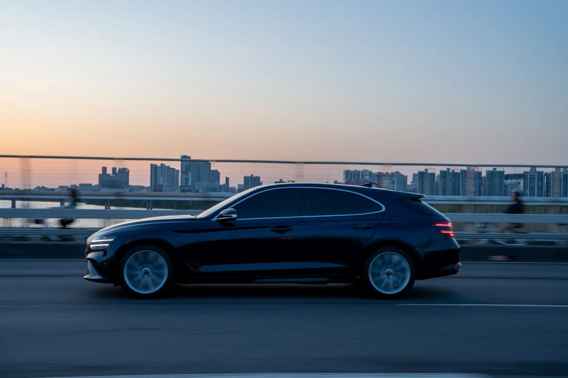 Luxury car speeding on Toronto bridge with cityscape backdrop